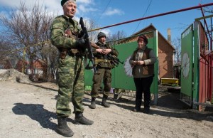 Soldiers of the Donetsk People's Republic speak to a resident in the frontline town of Shirokino, some 10 kms east of Mariupol, on March 20, 2015 (AFP Photo/John MacDougall) 